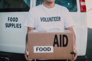 volunteer holding box of food aid